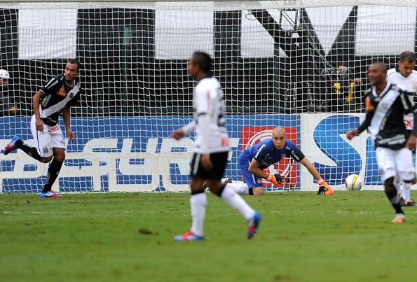 Roger(E), jogador da Ponte Preta, comemora seu gol observado por Júlio César(C, no chão), goleiro do Corinthians - Foto: Sérgio Barzaghi/Gazeta Press